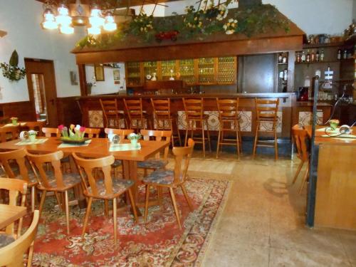 a restaurant with wooden tables and chairs and a bar at Hotel Andernacher Hof in Andernach