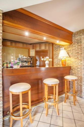 a restaurant with two stools and a bar with a counter at Hotel Le Drakkar in Pont-Audemer