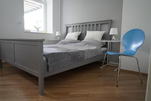 ミュルハイム・アン・デア・ルールにあるAltstadtwohnung mit eigenem Hauseingangのベッドルーム1室(ベッド1台、青い椅子付)