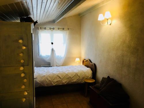 a bedroom with a bed and a window at Entre Vignes et Collines in Méthamis