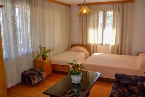 a hotel room with two beds and a glass table at Стаи за гости "КАТИ" Guest rooms "KATI" in Balchik