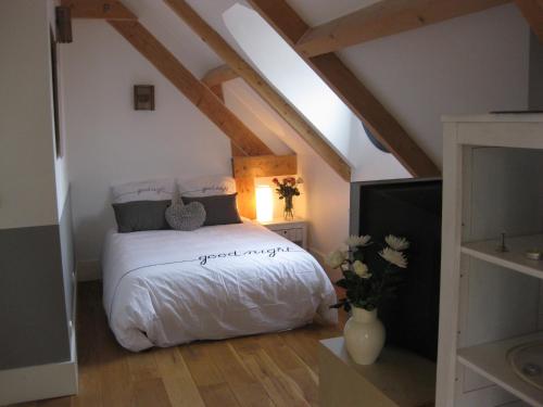 um quarto com uma cama branca num sótão em Beauséjour-Porte de Versailles Expo em Issy-les-Moulineaux
