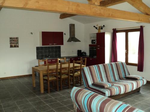 un salon avec un canapé et une table et une cuisine dans l'établissement Le Gîte du Clos Boisé, à Théziers