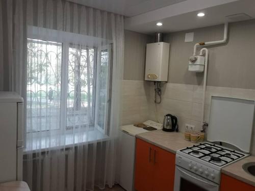 uma pequena cozinha com um fogão e uma janela em Apartment On Rabochaya 81 em Dnipro