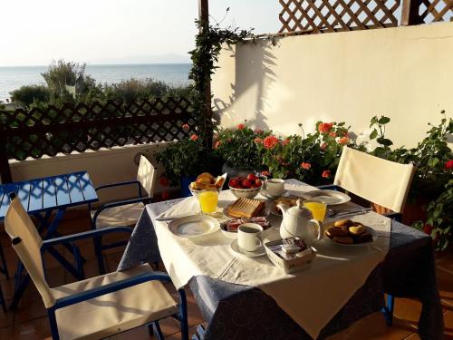 una mesa con comida y vistas al océano en Hotel Dimitra, en Tsoukalaíika