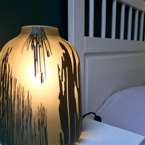 a brown vase sitting on a table next to a bed at De Reep in Geraardsbergen