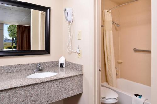 a bathroom with a sink and a shower and a phone at Americas Best Value Inn West Monroe in West Monroe