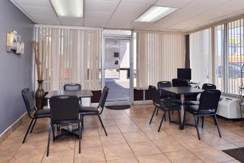 a conference room with black chairs and tables and windows at Americas Best Value Inn West Monroe in West Monroe