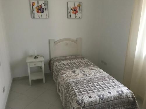 een kleine slaapkamer met een bed en een nachtkastje bij Casa Gigi in Olbia