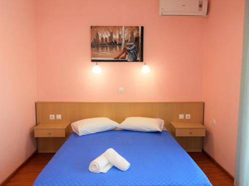 ein Schlafzimmer mit einem blauen Bett mit zwei Handtüchern darauf in der Unterkunft Apartment Christos Limenaria in Limenaria