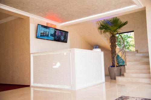 a room with a white wall with a tv on the wall at Le Mer in Afumaţi