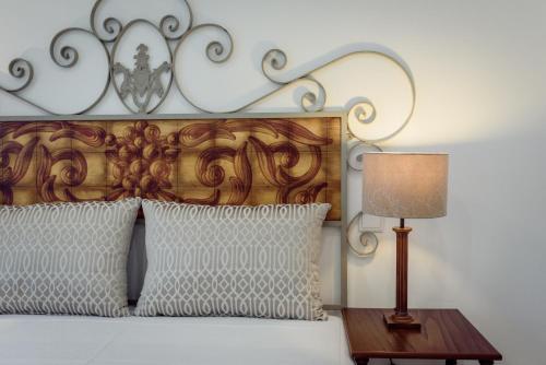 a bed with a wooden headboard and a table with a lamp at Casinhas Da Vila in Monção