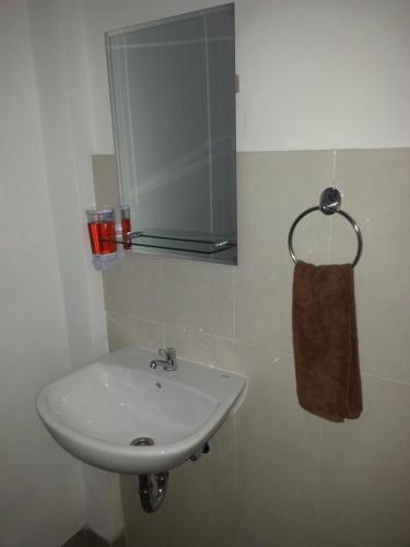 lavabo blanco en el baño con toalla en Ega Homestay, en Nusa Penida