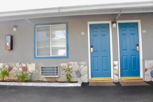 twee blauwe deuren aan de zijkant van een huis bij Arlington Motel in Long Beach