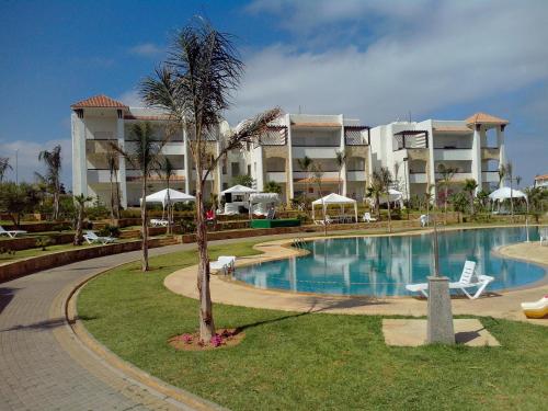 a resort with a swimming pool and a building at Marina golf Assila in Asilah