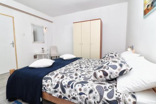 een slaapkamer met een bed met een blauw en wit dekbed bij Apartment Edi in Pula