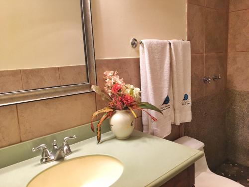 un baño con lavabo con un jarrón de flores. en Suite Rivas 126 Gran Pacifica Resort en San Diego