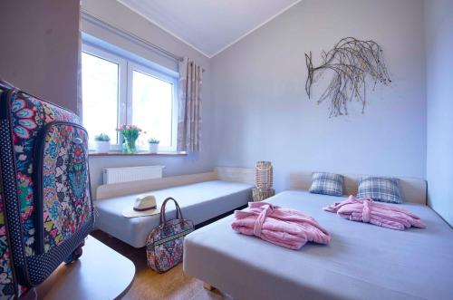 a room with two beds with pink towels on them at Arenda Apartamenty&Domki całoroczne in Sieraków