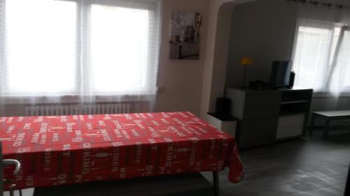 a bedroom with a red bed and a television at Les Jardins du Golf in Metz