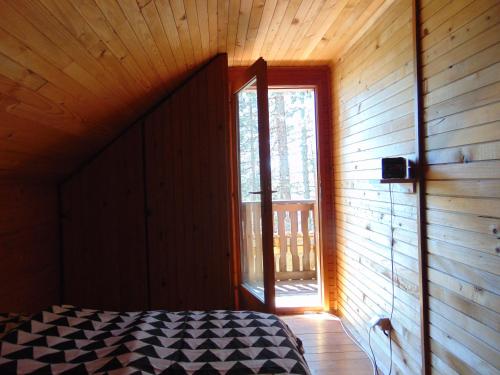 ein Schlafzimmer mit einem Bett und einem Fenster in einem Zimmer in der Unterkunft Tarski dom in Zaovine
