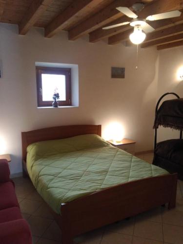 a bedroom with a bed with a green comforter and a window at B&B Medole in Medole
