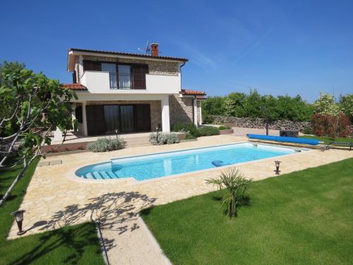 a villa with a swimming pool in front of a house at Villa Calypso in Krk