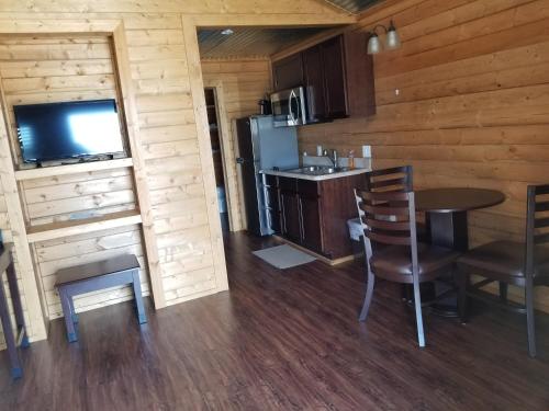 a kitchen and dining room with a table and a television at Paradise RV & Cabins Resort in Vinton