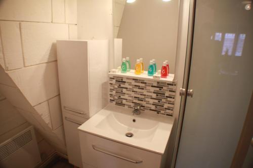 une petite salle de bain avec un lavabo et un miroir dans l'établissement Welcome Calais - SuperCalais, à Calais