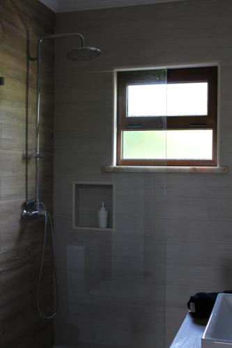 a bathroom with a shower and a sink and a window at Bela Vita, Porto Covo in Porto Covo
