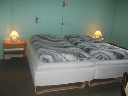 ein großes weißes Bett in einem Zimmer mit zwei Lampen in der Unterkunft Glyngøre Bed & Breakfast in Glyngøre