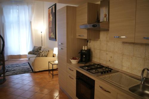 a kitchen with a stove top oven next to a living room at Astoria Suite in Salerno