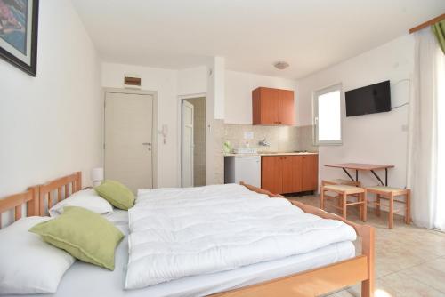1 dormitorio con 1 cama blanca grande y cocina en Apartmani Alexandra, en Budva