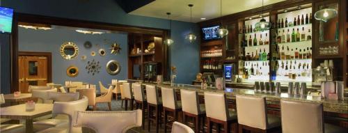 a restaurant with a bar with white tables and chairs at True 1BR Balcony Suite with Strip View at MGM Signature in Las Vegas