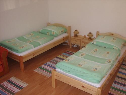 two twin beds in a room with wooden floors at Privat u Starona in Liptovský Ján