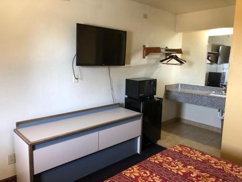 a room with a kitchen with a microwave and a counter at Lone Star Inn in Carrollton