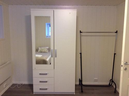a bedroom with a mirror and a white dresser at Barents Hotell in Kirkenes