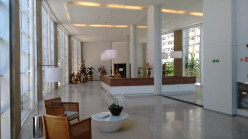 a lobby with chairs and a table in a building at O local para o seu lazer in Santos