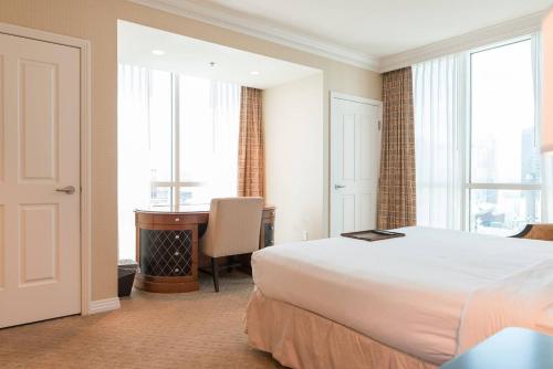una camera d'albergo con letto, scrivania e finestra di True 1BR Balcony Suite with Strip View at MGM Signature a Las Vegas