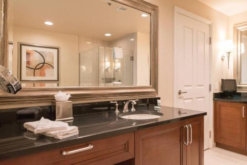 uma casa de banho com um lavatório e um espelho grande em True 1BR Balcony Suite with Strip View at MGM Signature em Las Vegas