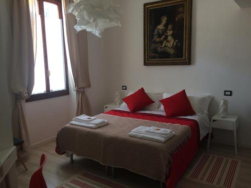 a bedroom with two beds with red pillows and a window at Roman Theater in Verona