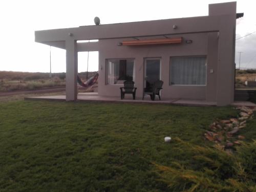 una pequeña casa con dos sillas en un patio en Casa Las Lomas El Nihuil en El Nihuil