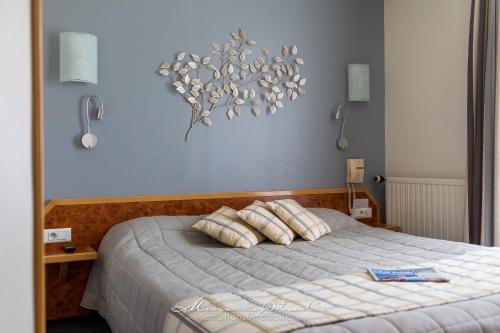 une chambre avec un lit avec des oreillers dessus dans l'établissement Beau Rivage, à Nogent-sur-Seine