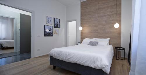 a bedroom with a large white bed and a mirror at Suite Vogue Espresso in Voghera