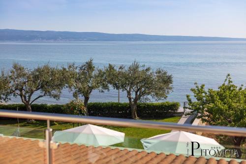 a view of the water from a balcony with two umbrellas at Villa Pitomcia in Podstrana