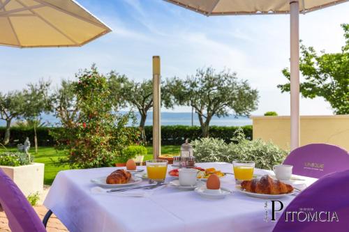 a table with food and orange juice on it at Villa Pitomcia in Podstrana