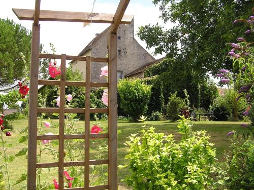 a wooden trellis in a garden with flowers at Le Pigeonnier du Perron Hôtel in Availles en Chatellerault