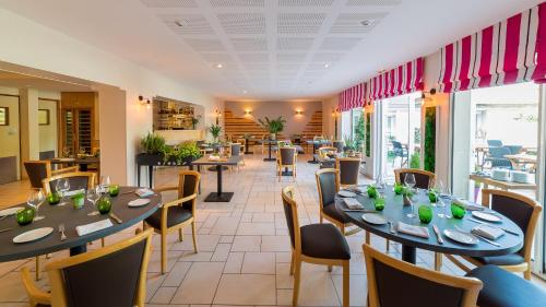 une salle à manger avec tables et chaises et un restaurant dans l'établissement Beau Rivage, à Nogent-sur-Seine