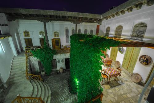a room with a staircase and green ivy in a building at Bibi-Khanym Hotel in Bukhara