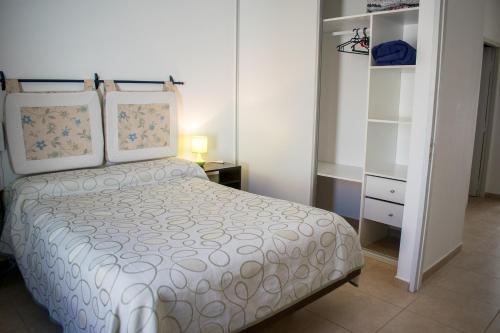 1 dormitorio con cama blanca y mesita de noche en Duplex Lisandro en San Rafael