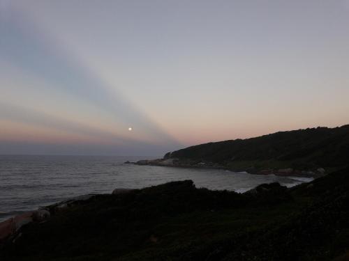 a view of the ocean at sunset at Vila Tamú in Praia do Rosa